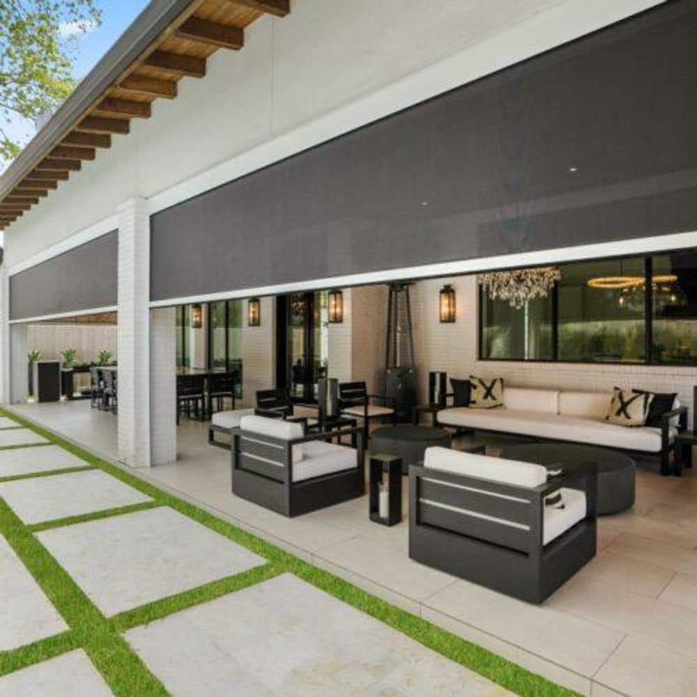 Stylish outdoor patio with modern seating, lush greenery, and elegant decor.